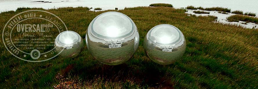 Three chrome orbs floating over green field